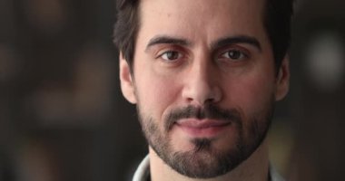 Yakın plan portre mutlu genç adam kameraya bakıyor.