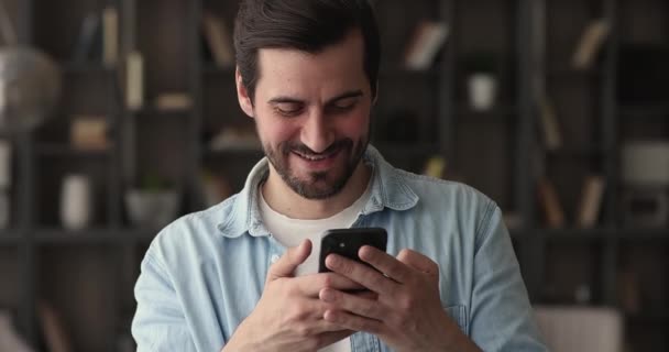 Feliz joven 30s hombre disfrutando con el teléfono inteligente. — Vídeos de Stock