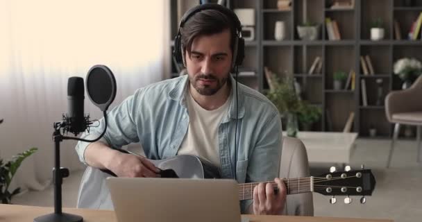 Koncentrált fiatalember énekel dal nézi a számítógép képernyőjén. — Stock videók