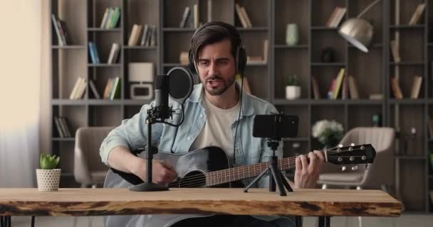 젊고 행복 한 남성 음악가가 휴대폰으로 노래를 녹음 하는 모습. — 비디오