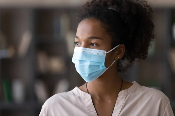Young biracial woman in facemask look in distance — Stock Photo, Image
