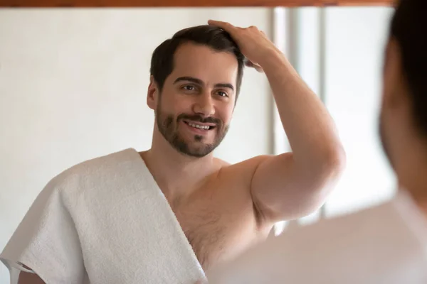 Smiling man look in mirror in bath style hair — Stock Photo, Image