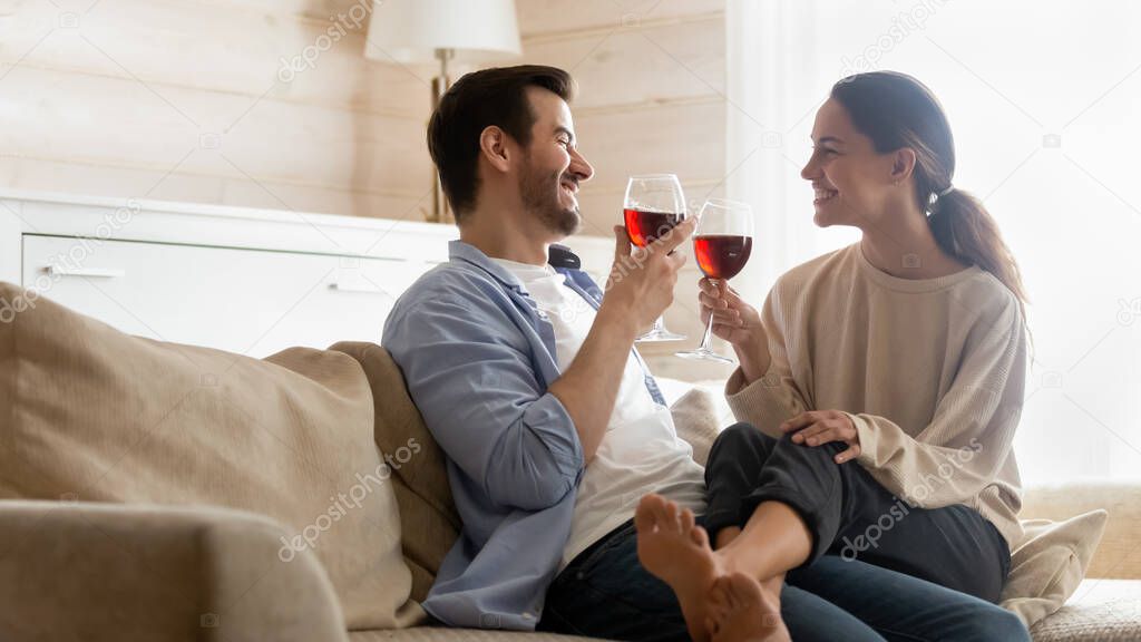 Happy couple relax at home celebrating with wine