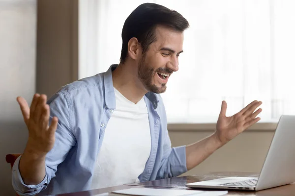 Excited young man use laptop read good news online