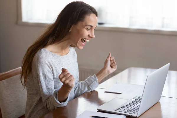 Overjoyed young woman triumph with good news on computer — Stock Photo, Image