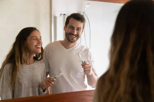Sonriente pareja cepillarse los dientes en el baño en casa por la mañana — Foto de Stock
