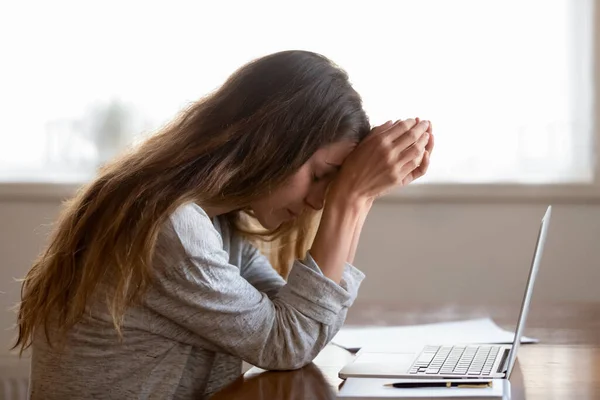 Несчастная белая женщина напряжена плохим сообщением на ноутбуке — стоковое фото