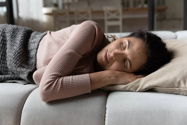 Wanita latin yang tenang tidur siang di sofa menikmati istirahat yang nyaman — Stok Foto