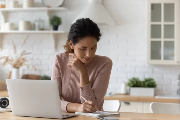 Young woman listen to lesson on pc check written records