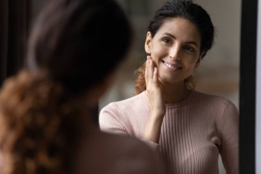 Bin yıllık İspanyol kadın aynaya bak ve taze sağlıklı cildin tadını çıkar.