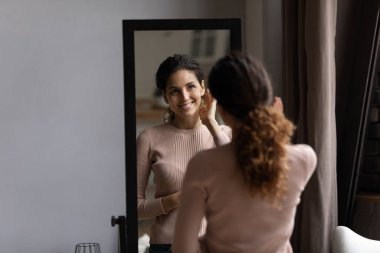 Genç İspanyol kadın aynanın karşısında dur ve mükemmel yüz derisinin tadını çıkar.