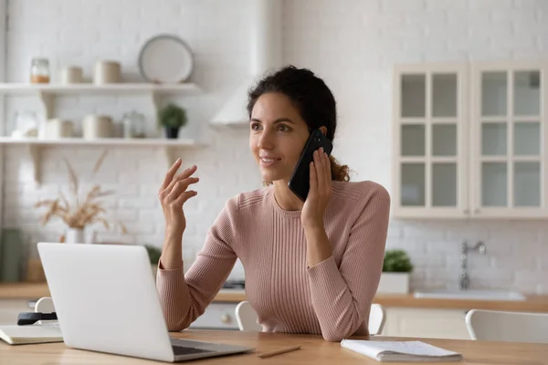 Inspired hispanic woman remote worker sitting by laptop making call — Stock Photo, Image