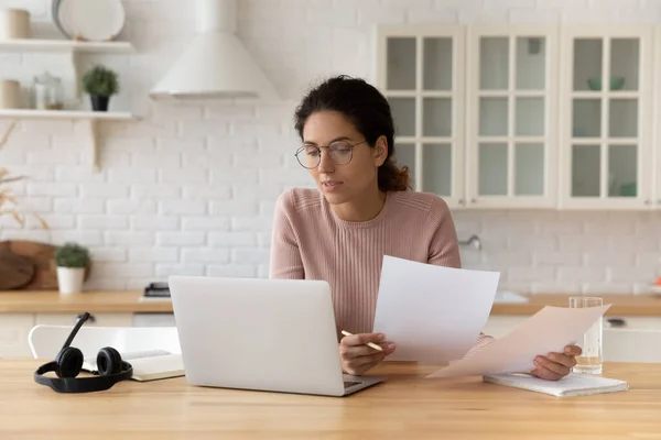 Pensativo hispano mujer celebrar documentos financieros mirar en la pantalla de la PC — Foto de Stock