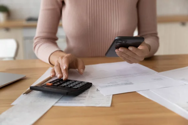 Young female use phone calculator to manage financial documents bills — Stock Photo, Image