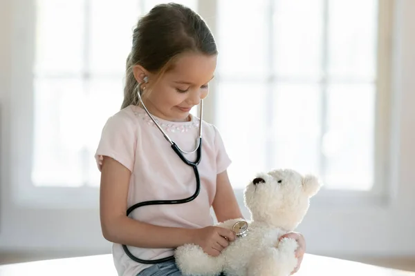 Cute little girl play hospital with teddy bear toy — Stock Photo, Image