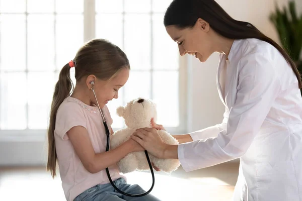 Speelse verpleegster spelen met kleine meisje patiënt — Stockfoto
