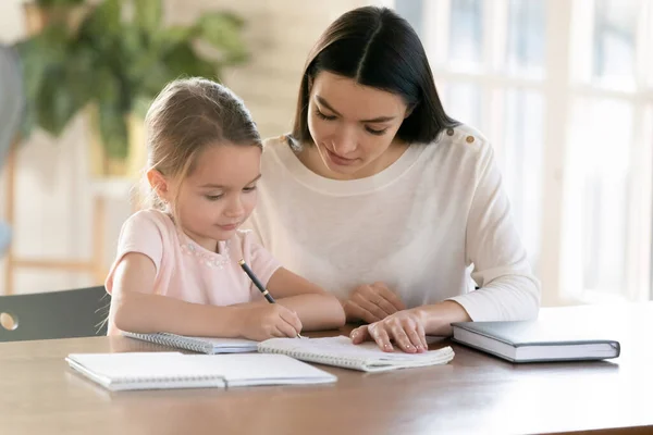 Caring mom study at home with little daughter