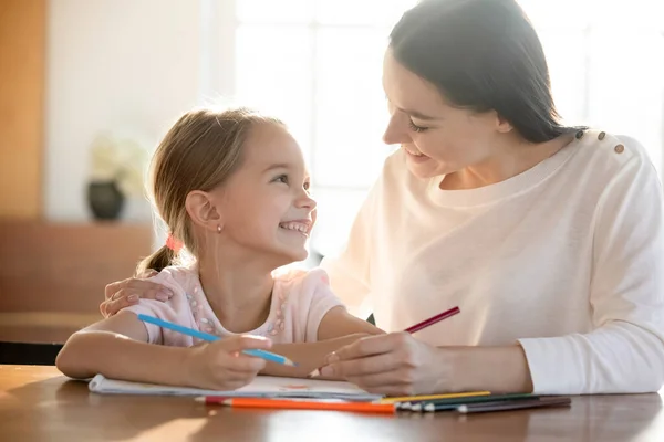 Sonriente joven mamá y su hija pequeña dibujo —  Fotos de Stock