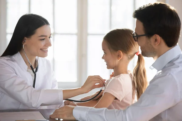 Vårdande kvinnlig barnläkare lyssna på barn hjärta med stetoskop — Stockfoto