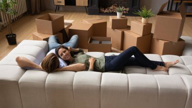 Mutlu bir aile yeni daireye taşındıktan sonra kanepede dinleniyor.