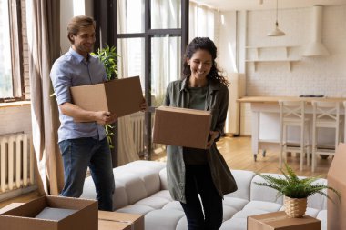 Karton kutular taşıyan mutlu bir aile, yeni bir daireye taşınıyor.