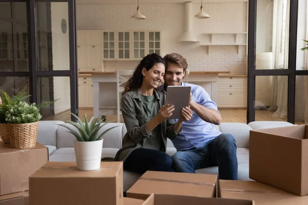 Pareja feliz usando la tableta, eligiendo el servicio móvil para la reubicación —  Fotos de Stock