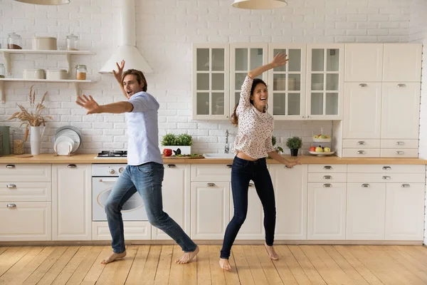 Överlycklig ung par dansar i köket, har kul tillsammans — Stockfoto