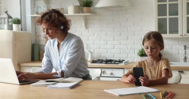 Bu arada çalışan anne kız akıllı telefon kullanarak oyun oynuyor.