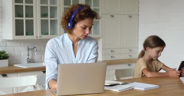 Mientras mamá hija trabajadora pasar tiempo con el teléfono inteligente moderno — Vídeos de Stock