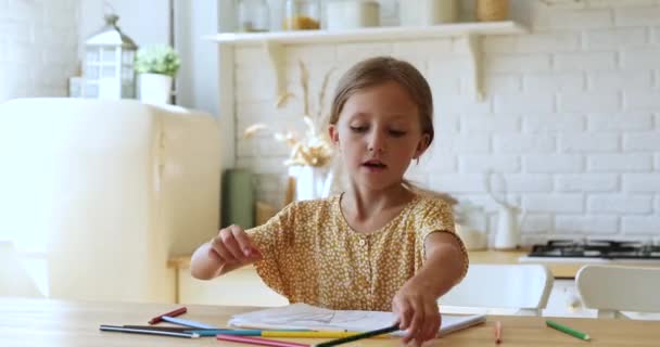Dívka dělá chaotické pohyby kreslení s barevnými tužkami — Stock video