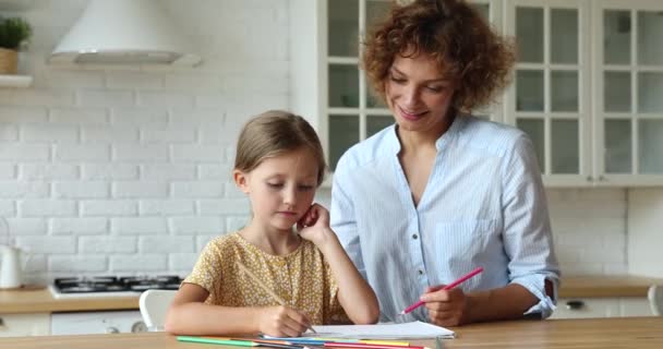 Креативна маленька дівчинка малює олівцями час з матір'ю — стокове відео