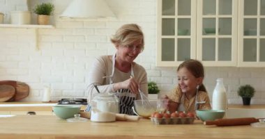 Sevgi dolu büyükanne küçük tatlı torununa yemek yapmayı öğretir.