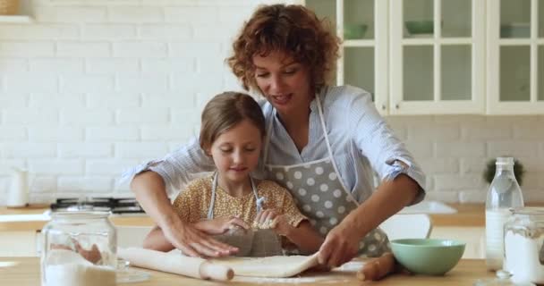 Anya azt tanítja a lányának, hogy készítse elő a házi süteményt. — Stock videók