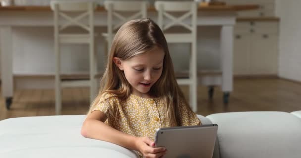 Klein meisje met behulp van tablet genieten plezier en vrije tijd thuis — Stockvideo