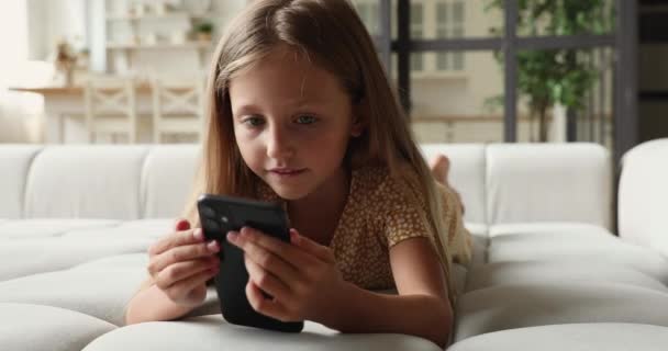 Linda menina adorável descansando em casa com smartphone moderno — Vídeo de Stock