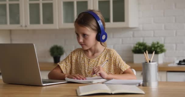Estudante tomar notas enquanto ouve curso de áudio através de fones de ouvido — Vídeo de Stock