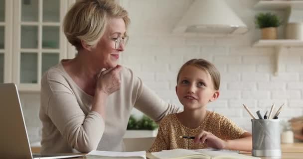 La nonna parla con la nipotina mentre fa i compiti a casa — Video Stock