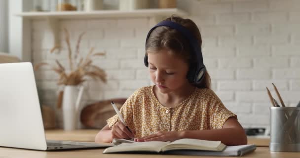 Liten flicka gör uppdrag, prata med lärare genom videosamtal — Stockvideo