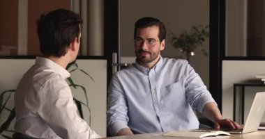 Gülümseyen işadamı, iş ortağıyla el sıkışıyor..