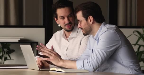 Dos colegas varones jóvenes que trabajan en un proyecto en línea. — Vídeos de Stock