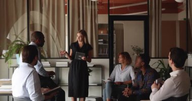 İş arkadaşlarıyla görüşmede gülümseyen genç bayan iş kadını.