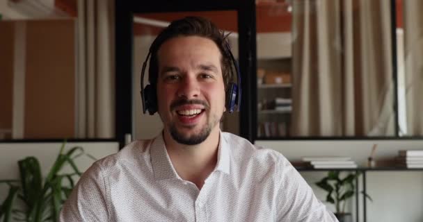 Ung latinsk forretningsmand i hovedtelefoner, der holder forhandlingsmøde. – Stock-video