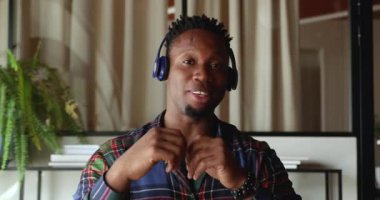 Gülümseyen Afrikalı Amerikalı genç bir adam internette iş görüşmesi yapıyor..