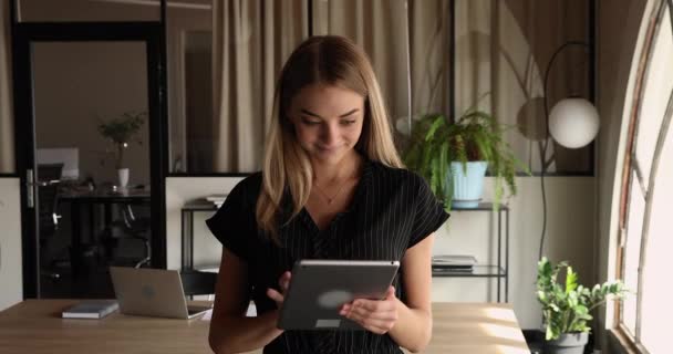 Feliz joven milenaria dama de negocios utilizando tableta de computadora digital. — Vídeo de stock