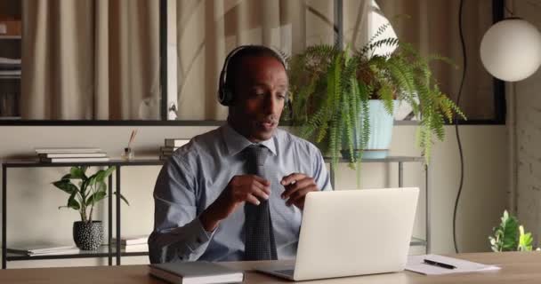 Sérieux 40s jeune homme d'affaires afro-américain tenant une réunion par vidéoconférence. — Video
