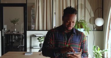 Dijital tablet kullanan mutlu Afro-Amerikan erkek çalışanı.