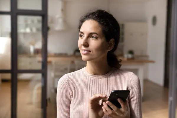 Millennial female hold cell look aside before answer on message — Stockfoto