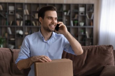 Gülümseyen erkek müşteri internetten cep telefonuyla konuşuyor.