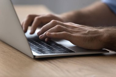 Dizüstü bilgisayarda klavye kullanan genç adama yaklaş.