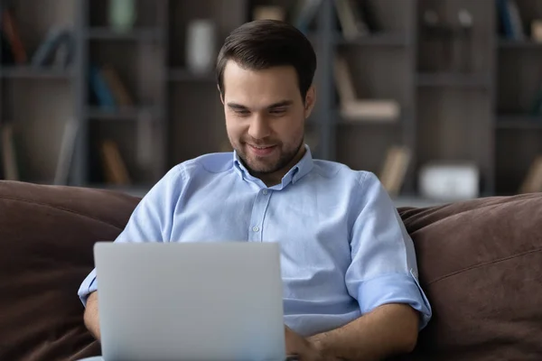 Feliz hombre caucásico trabajar en el ordenador portátil en casa —  Fotos de Stock